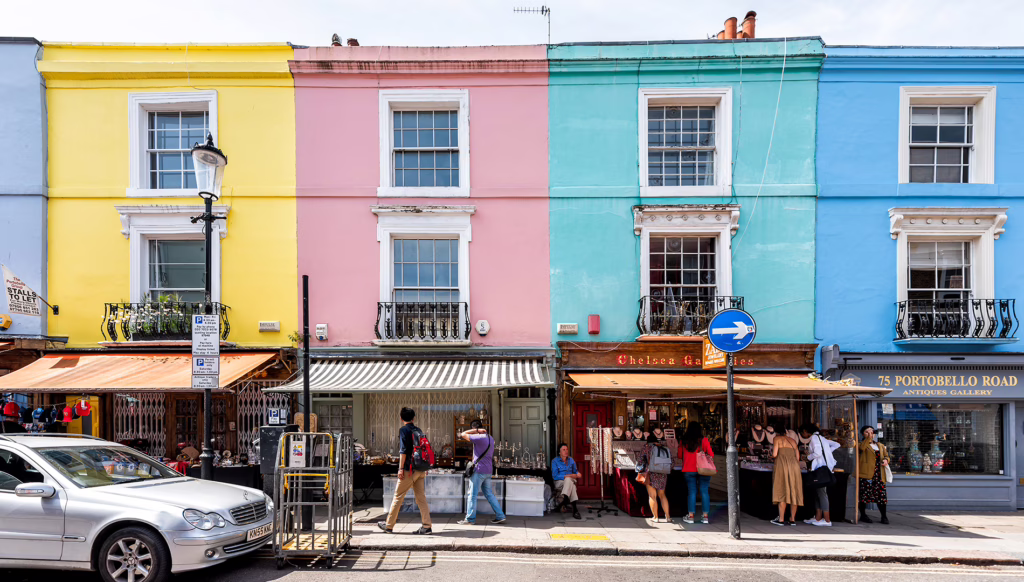 Neighbourhood district of Notting Hill, street, colorful multicolored famous style flats architecture facade, road, people shopping in iconic centre, Portobello