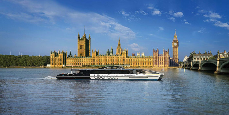 Uber boat floating on the River Thames with the Houses of Parliment and Big Ben behind