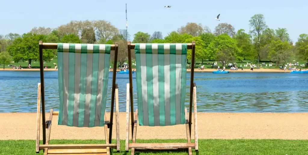 Two deck chairs overlooking Hyde Park's pond in the summer