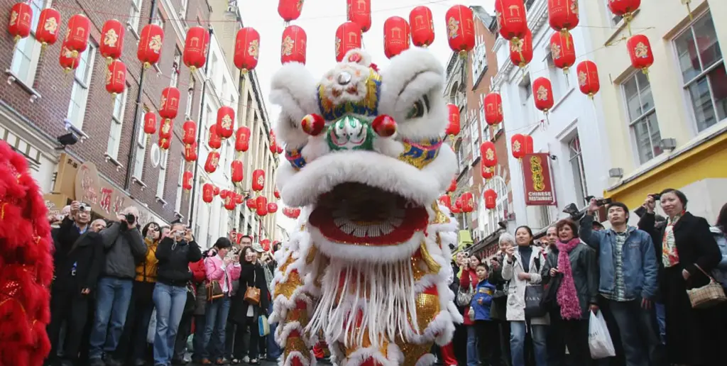 Chinese Dragon in parade below red paper lanterns