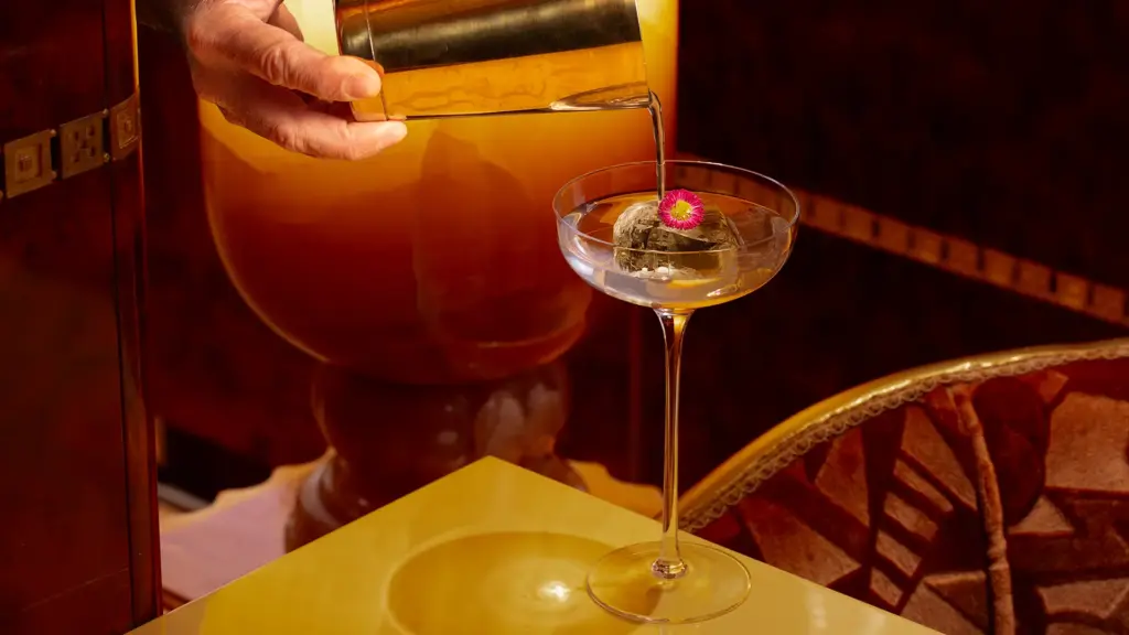 Bartending pouring cocktail into a glass